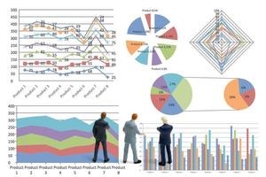 Miniature businessmen standing with charts on a white background photo