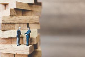 Miniature businessmen standing on woodblocks photo