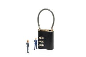 Miniature businessmen helping to unlock the password on a lock, business solution concept photo