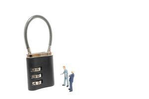 Miniature businessmen helping to unlock the password on a lock, business solution concept