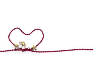 Miniature workers building a heart-shaped rope on a white background photo