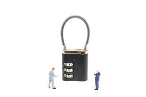 Miniature businessmen helping to unlock the password on a lock, business solution concept photo