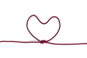 Heart-shaped knot on a rope on a white background photo