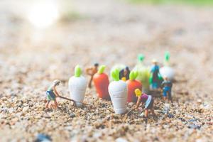 Miniature gardeners harvesting vegetables, agriculture concept photo