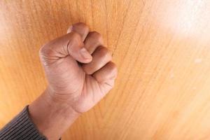 Young man's hand knocking on a door photo