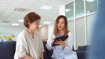 jovem médico conversando com paciente sênior em uma clínica video