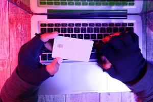 Hacker's hand stealing data from credit card photo