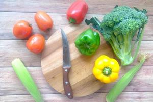 Selección de alimentos saludables con verduras frescas en una tabla de cortar en la mesa