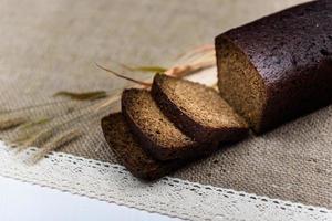 Black whole grain bread sliced on the table photo