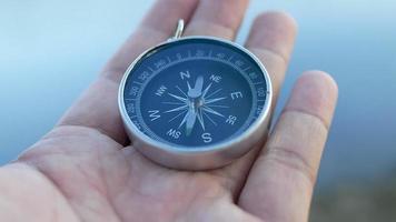 close-up van de hand met een kompas over de natuur achtergrond video