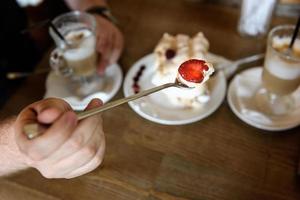 Spoon of meringue with strawberries photo