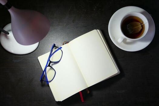 high angle view of open notepad and table lamp photo