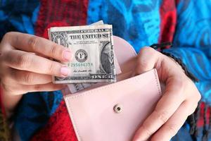 Close up of women hand saving cash in wallet photo