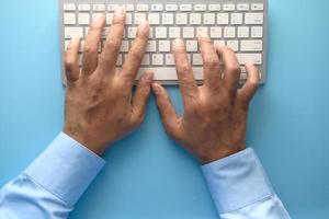 Close up of man's hand typing on keyboard photo