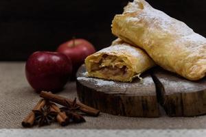 Strudel de manzana en el extremo de madera de un árbol con manzanas, canela y anís estrellado foto