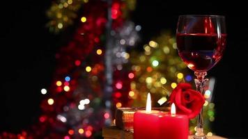 rote Rose und Wein und Kerze mit buntem Bokeh im Hintergrund video