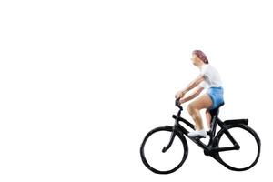 Miniature figure riding a bicycle isolated on a white background photo