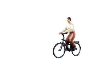 Miniature figure riding a bicycle isolated on a white background photo