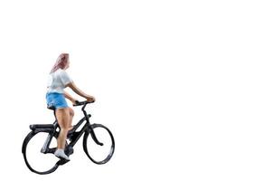 Miniature figure riding a bicycle isolated on a white background photo
