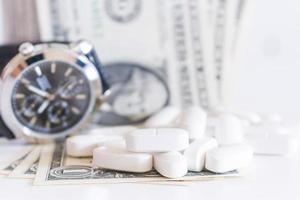 White pills and money on a white background photo