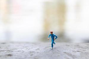 Gente en miniatura corriendo sobre una roca, concepto de salud y estilo de vida foto