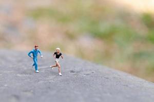 Gente en miniatura corriendo sobre una roca, concepto de salud y estilo de vida foto