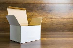 Caja de papel blanco sobre un fondo de mesa de madera foto