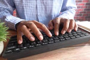 Cerca de la mano del hombre escribiendo en el teclado foto