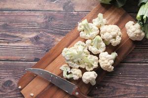 Knife and cauliflower on chopping board photo