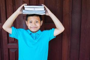 Boy holding books on head photo
