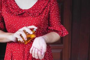 mujer aplicando perfume en su muñeca foto