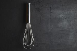Whisk on a black background photo