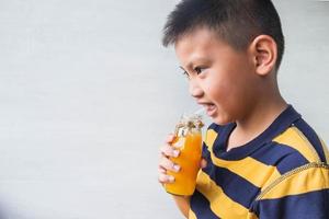 Boy drinking orange juice photo