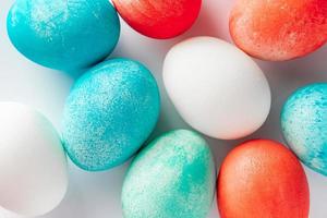 Primer plano de huevos de Pascua multicolores sobre un fondo blanco. foto