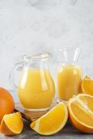 Glass pitchers of fresh juice with sliced orange fruit photo