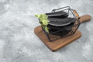 Fresh raw eggplant vegetables placed in a metallic basket