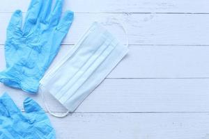 Surgical masks and medical gloves on wooden background photo