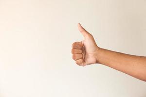 Man showing a thumbs-up on neutral wall photo
