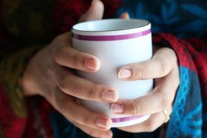 Close up of woman's hand holding coffee mug photo