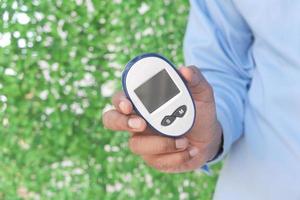 Young man holding diabetic measurement tool photo