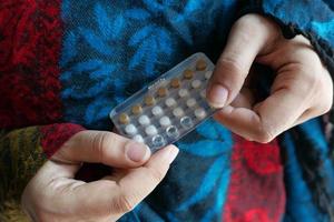 Woman holding birth control pills photo