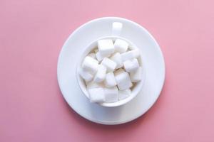 Top view of sugar cubes on pink background photo