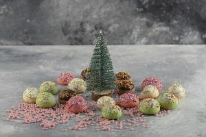 Colorful sweet small doughnuts with sprinkles and a Christmas ornament photo