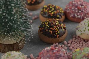 Colorful sweet small doughnuts with sprinkles and a Christmas ornament photo