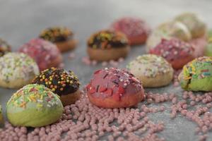 donas pequeñas y dulces de colores con chispas foto