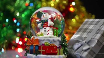 esfera de boneco de neve e caixa de presente em bokeh de fundo natal video