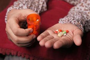 Close up of women hand taking pills photo
