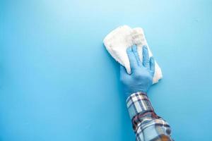 Persona mano en guantes de látex mesa de limpieza con paño foto