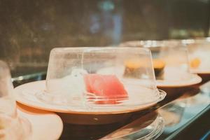 bandeja de sushi en cinta transportadora foto
