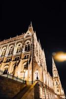 El parlamento húngaro en Budapest sobre el Danubio en las luces nocturnas de las farolas foto